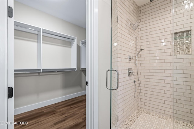 bathroom featuring wood-type flooring and a shower with shower door