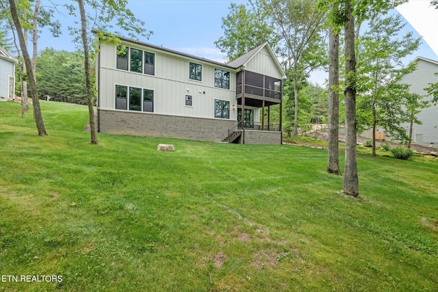 rear view of house with a lawn and a sunroom