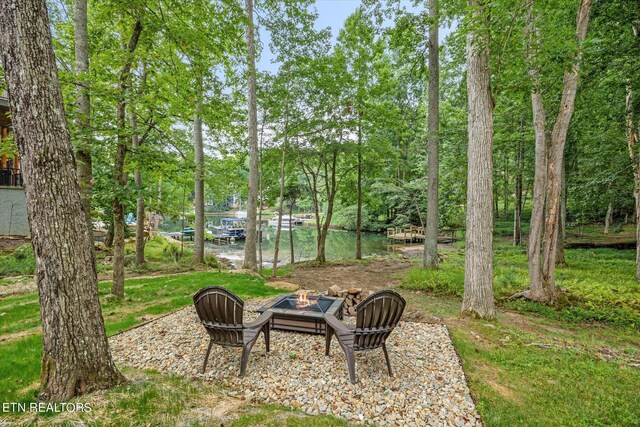 view of yard with a water view and a fire pit