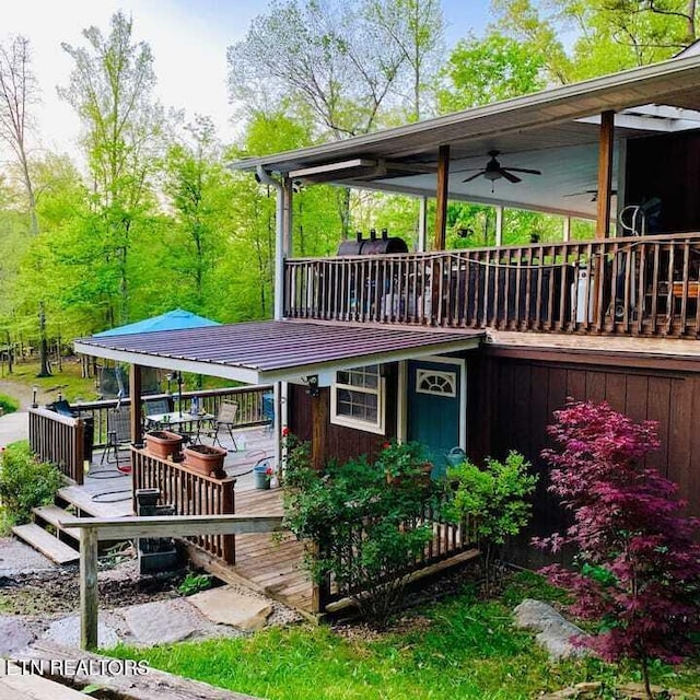 view of front facade with a wooden deck and ceiling fan