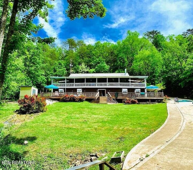 view of front of property featuring a storage shed, a front lawn, an outbuilding, and a wooden deck