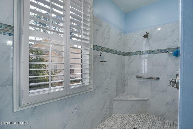 bathroom with tile walls and a tile shower