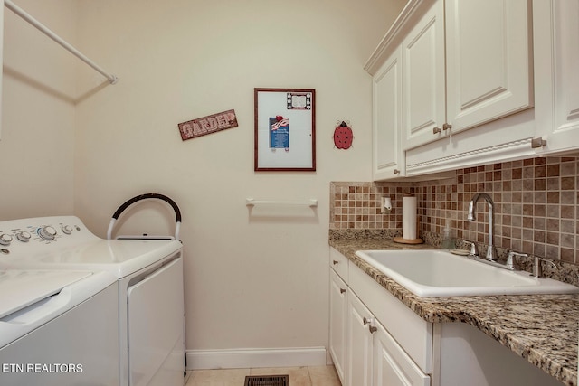 laundry room with light tile patterned flooring, cabinets, sink, and washer and dryer