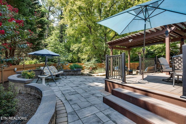 view of patio featuring a wooden deck and a pergola