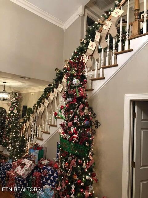 stairway featuring crown molding and a notable chandelier