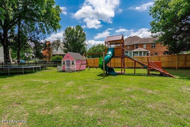 view of jungle gym with a trampoline, a shed, and a yard