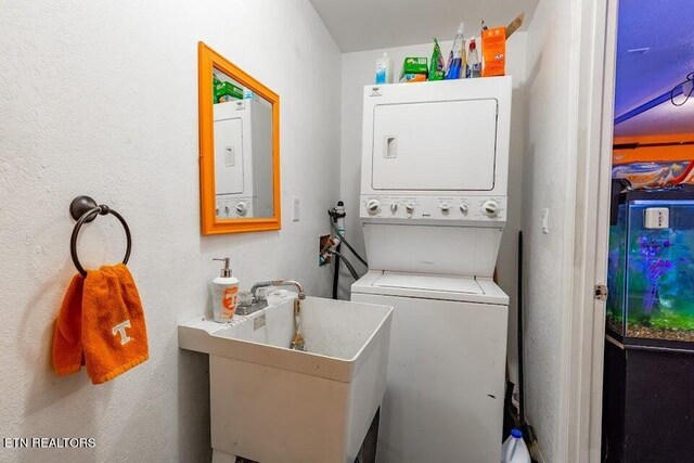 clothes washing area featuring sink and stacked washer / drying machine