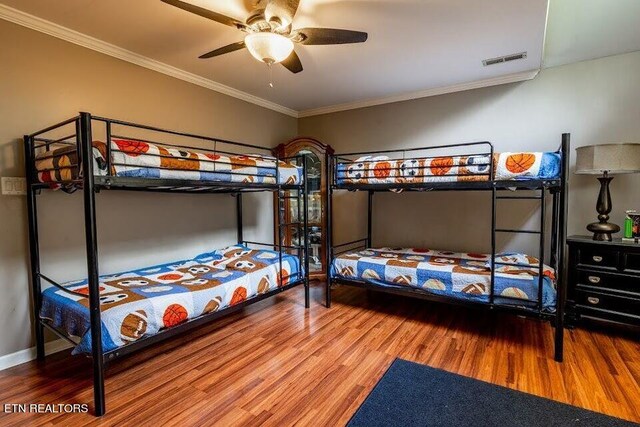 bedroom with ceiling fan, hardwood / wood-style floors, and crown molding