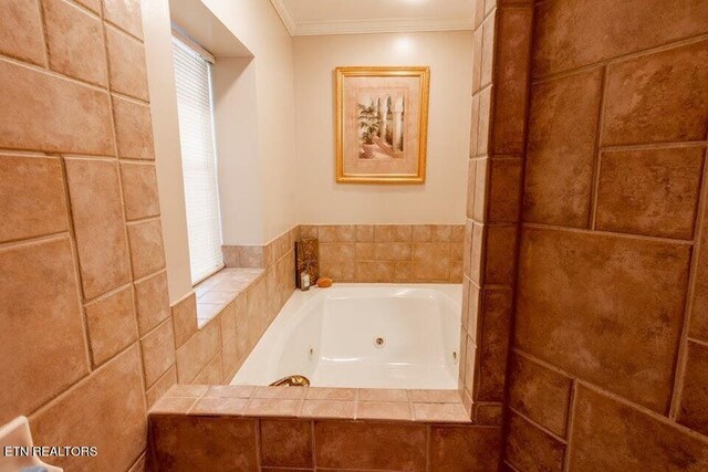 bathroom with tiled tub and crown molding