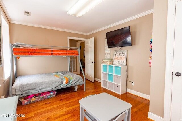 bedroom with hardwood / wood-style flooring and crown molding