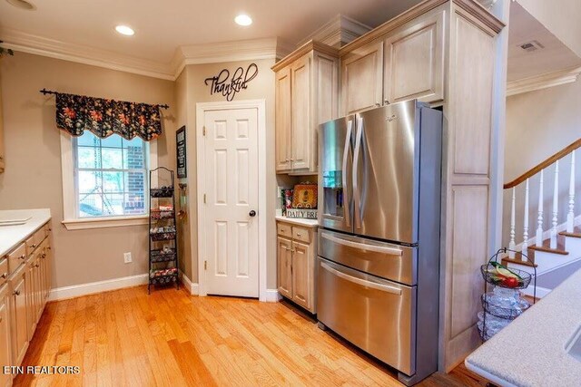 kitchen featuring light hardwood / wood-style floors, ornamental molding, stainless steel refrigerator with ice dispenser, and light brown cabinetry