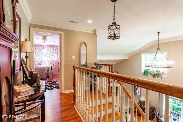 corridor featuring a chandelier, crown molding, vaulted ceiling, and dark wood-type flooring