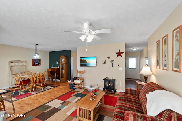 living room featuring a textured ceiling, hardwood / wood-style floors, and ceiling fan