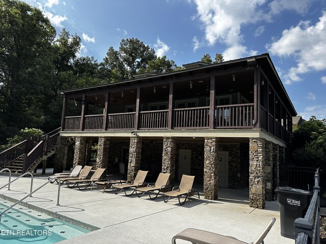 back of house featuring a community pool, ceiling fan, and a patio area