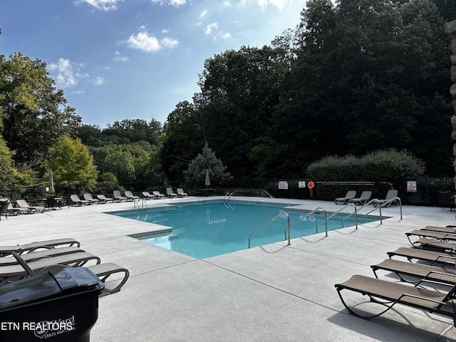 pool with a patio and fence