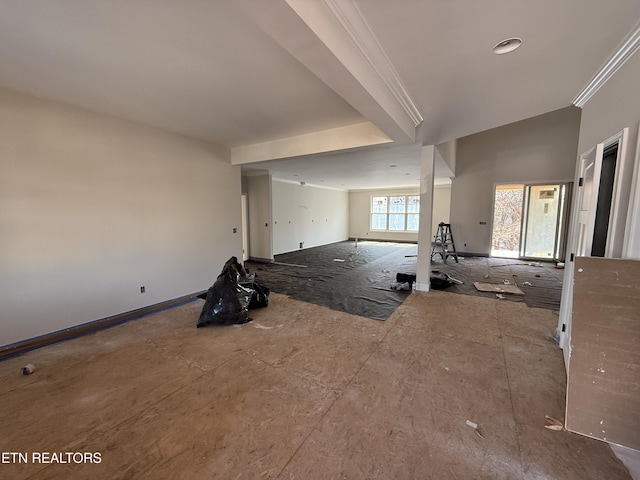 unfurnished living room featuring baseboards and ornamental molding