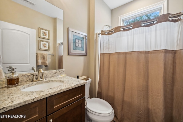 bathroom with toilet, a shower with curtain, visible vents, and vanity