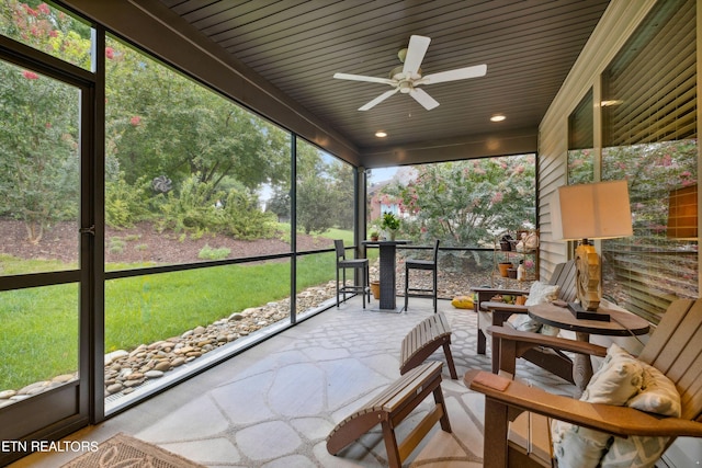 unfurnished sunroom with a ceiling fan and wooden ceiling