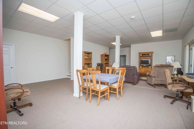 carpeted dining space with a drop ceiling