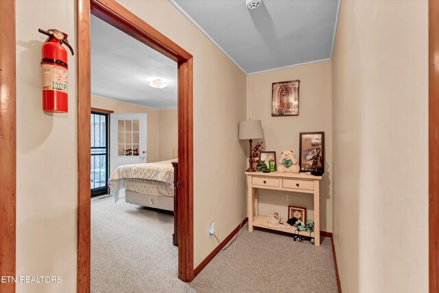 hall featuring crown molding and light colored carpet