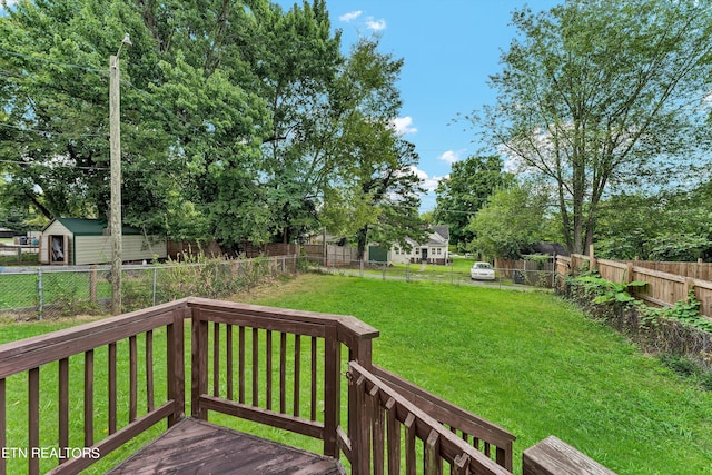 wooden terrace with a shed and a yard