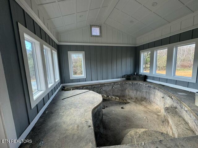 unfurnished sunroom with lofted ceiling