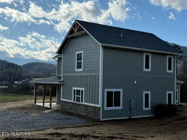 view of side of home with a mountain view and a patio area