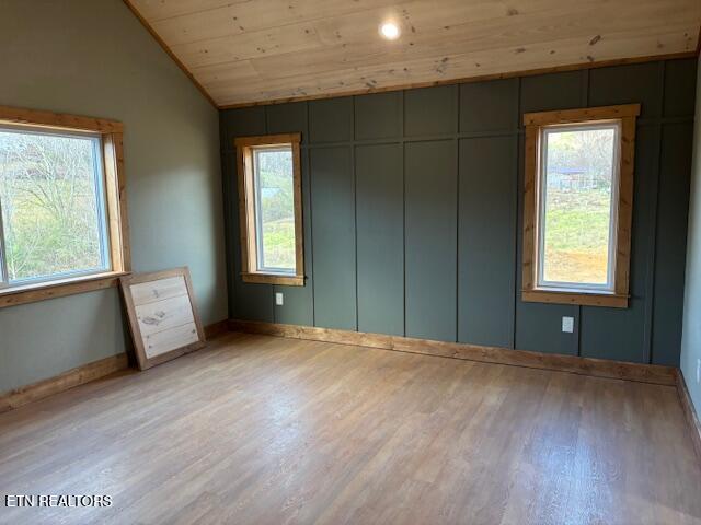 unfurnished bedroom with multiple windows, wooden ceiling, vaulted ceiling, and light hardwood / wood-style floors