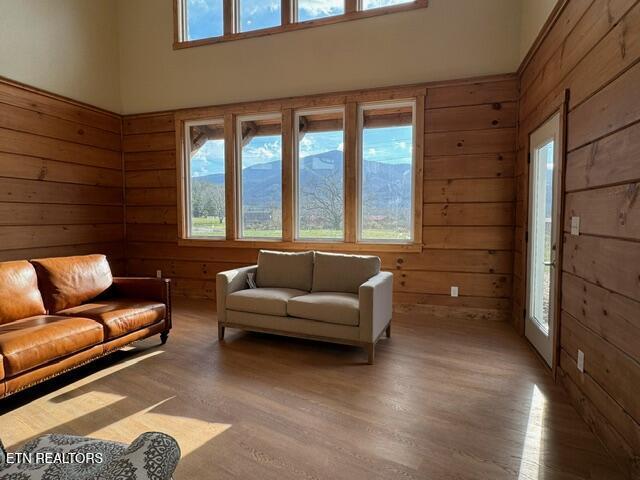 living room with wooden walls, plenty of natural light, and hardwood / wood-style flooring