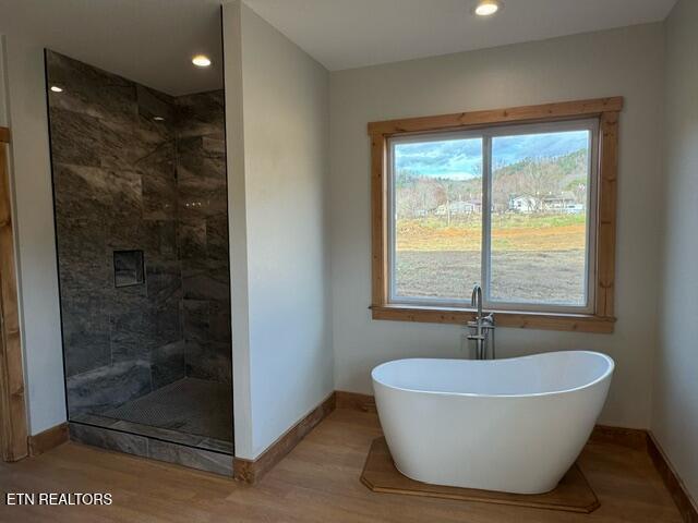 bathroom featuring hardwood / wood-style floors and shower with separate bathtub