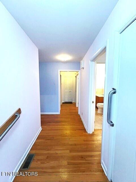 corridor with hardwood / wood-style floors