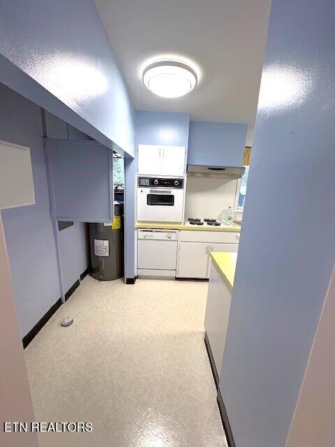 kitchen with white cabinetry, white appliances, and electric water heater