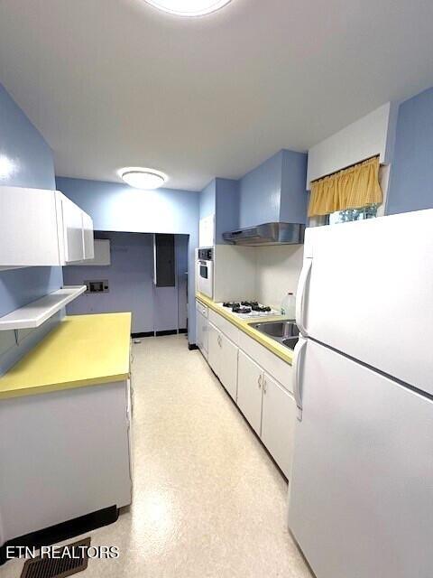 kitchen featuring white cabinets, white appliances, and wall chimney exhaust hood