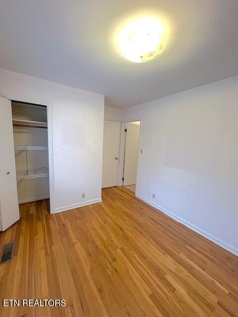 unfurnished bedroom featuring light wood-type flooring and a closet