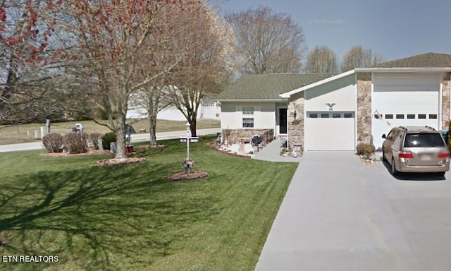 view of front of property featuring driveway, a front yard, an attached garage, and stone siding