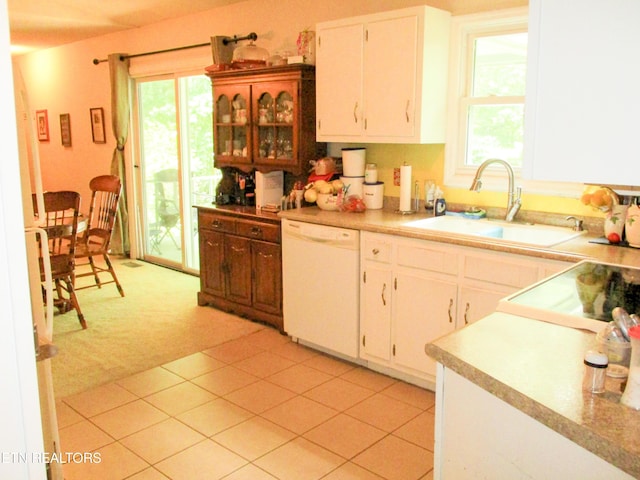 kitchen with white dishwasher, sink, white cabinetry, and light carpet