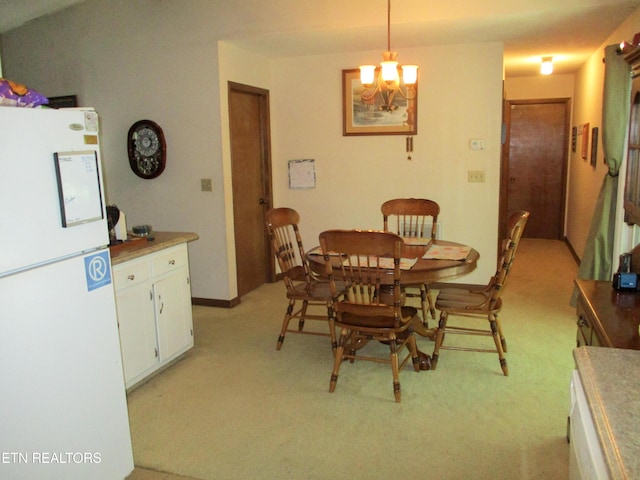 dining space with light colored carpet and a notable chandelier