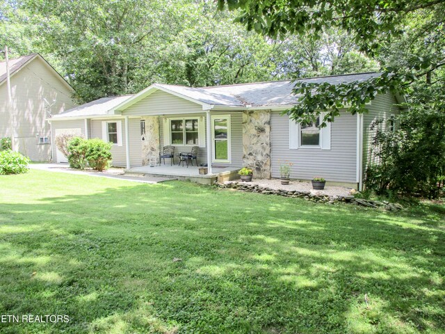 ranch-style house featuring a front lawn and a patio area