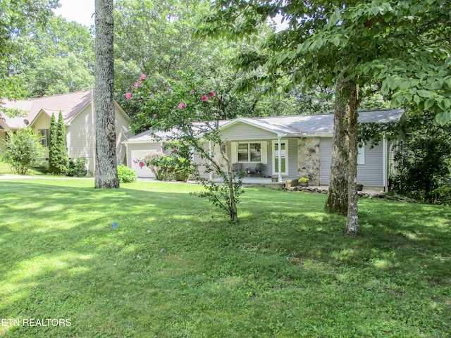 view of front facade with a garage, covered porch, and a front yard