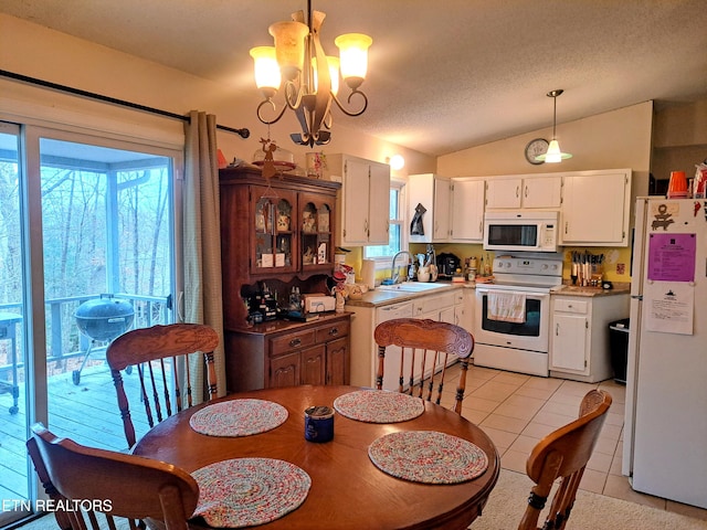 tiled dining space featuring vaulted ceiling, a healthy amount of sunlight, sink, and a textured ceiling