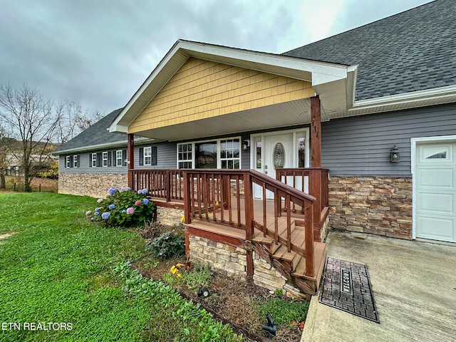 view of front facade featuring a porch, a garage, and a front yard