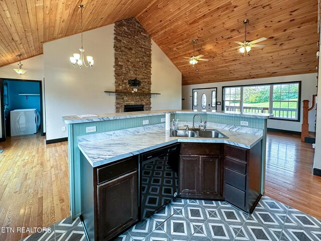 kitchen featuring hardwood / wood-style floors, a fireplace, ceiling fan with notable chandelier, high vaulted ceiling, and dishwasher