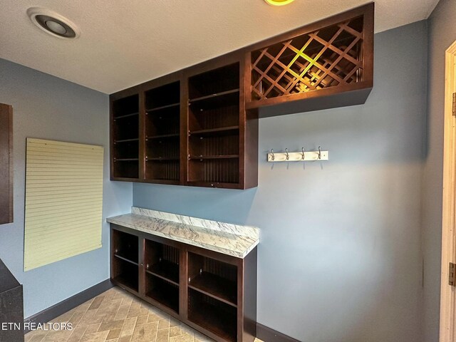 interior space with a textured ceiling and light tile patterned floors