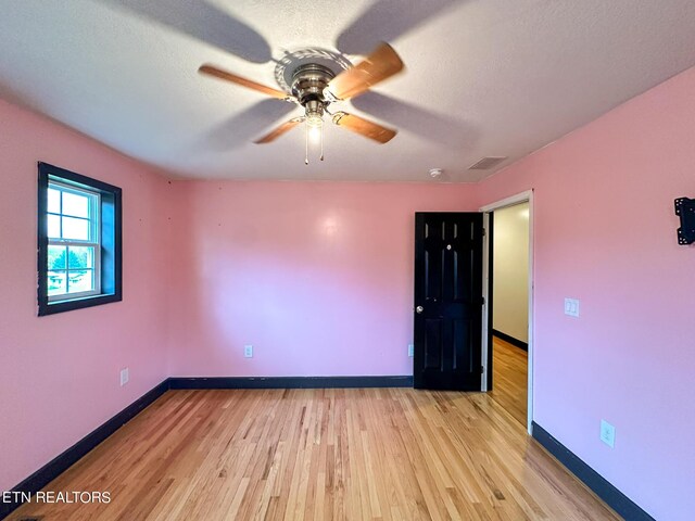 unfurnished room with a textured ceiling, ceiling fan, and light hardwood / wood-style floors