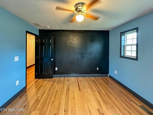 empty room featuring light wood-type flooring and ceiling fan