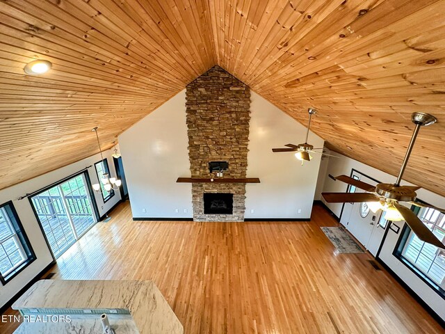 unfurnished living room featuring light hardwood / wood-style flooring, a stone fireplace, high vaulted ceiling, and wood ceiling