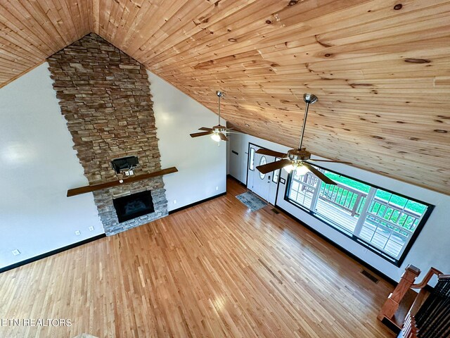 unfurnished living room featuring ceiling fan, wooden ceiling, high vaulted ceiling, light hardwood / wood-style flooring, and a stone fireplace