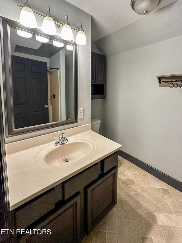 bathroom with vanity, tile patterned flooring, and toilet