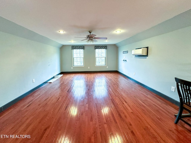 interior space featuring an AC wall unit, wood-type flooring, and ceiling fan