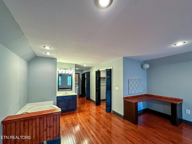 kitchen featuring sink, a textured ceiling, blue cabinets, and wood-type flooring